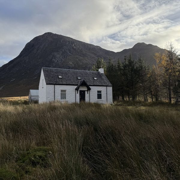 Casa branca isolada ao pé de uma montanha